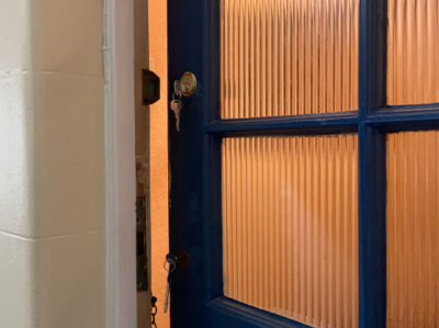 A person lubricating a lock with a silicone based spray lubricant